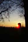 The sun sets over the milestone.